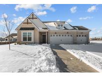 Two story home with gray siding and a three-car garage, snow covered front yard at 5034 Bergamot Dr, Brownsburg, IN 46112