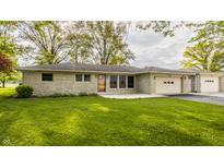 Charming single-story home featuring a stone facade, attached two-car garage, and lush green lawn at 5861 S 100 W, Fountaintown, IN 46130