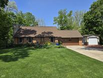 Charming brick home features a well-manicured lawn and lovely landscaping with a two-car garage and additional outbuilding at 6605 Donnelly Dr, Brownsburg, IN 46112