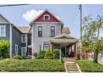 Charming two-story home with mature landscaping and a welcoming front porch and well-maintained exterior at 2036 N Talbott St, Indianapolis, IN 46202
