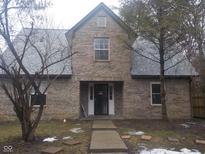 Traditional brick home featuring a symmetrical design, a covered front porch, and a well-maintained lawn at 2021 N Graham Ave, Indianapolis, IN 46218