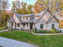 Stunning stone-clad home boasts professional landscaping, elegant roofline, and a welcoming front porch at 7258 N Richardson Dr, Morgantown, IN 46160