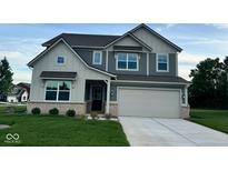 Two-story house with gray and beige siding, a large driveway, and a neatly landscaped lawn at 1191 Taggart Way, Greenwood, IN 46143
