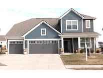 Charming two-story home with a three-car garage, landscaped front yard, and inviting covered porch at 13037 Corydon Dr, Fishers, IN 46037