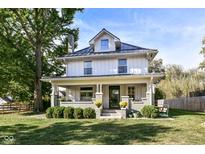 Two-story house with gray brick and white siding, metal roof, and porch at 4902 N Park Ave, Indianapolis, IN 46205