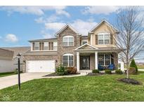 Two-story brick home with a welcoming front porch and landscaped lawn at 6252 Sugar Maple Dr, Zionsville, IN 46077