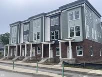 Newly constructed townhomes featuring brick and siding exteriors, white columns, and large windows at 2607 E New York St, Indianapolis, IN 46201