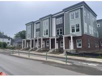Newly constructed townhomes feature brick facades, white columns and a modern color scheme at 2609 E New York St, Indianapolis, IN 46201