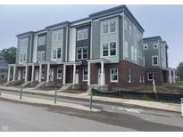 Modern townhomes boast a stylish brick and siding facade, white pillars, and large windows at 2611 E New York St, Indianapolis, IN 46201