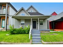 Charming single-story home with a covered front porch, landscaped yard and blue painted stairs at 1709 Hoyt Ave, Indianapolis, IN 46203