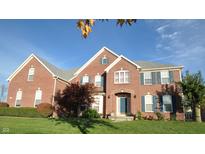 Charming two-story brick home with a well-manicured lawn and mature landscaping at 12583 Robinbrook Dr, Carmel, IN 46033