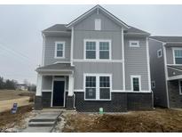 Two-story home features gray siding, black brick foundation, white trim, covered front porch at 12020 Gia Ct, Noblesville, IN 46060