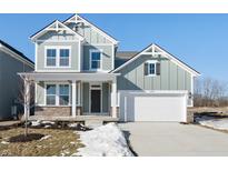 Two-story craftsman style home with a white garage door and landscaping at 14309 Coyote Ridge Dr, Noblesville, IN 46060
