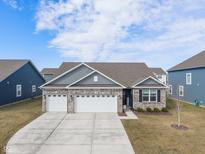 Charming brick-and-siding home featuring a three-car garage and well-manicured front yard at 346 Limerick Ln, Pendleton, IN 46064