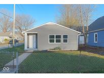 Charming single-story home featuring gray siding, crisp white trim, and a well-maintained lawn at 1601 Draper St, Indianapolis, IN 46203