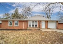 Charming single-story brick home featuring a manicured lawn and attached garage at 1827 Lowell Ave, Anderson, IN 46011
