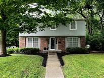 Charming two-story home featuring a landscaped yard and a mix of brick and gray siding facade at 4902 N Capitol Ave, Indianapolis, IN 46208