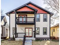 Two-story home with eye-catching red and black accents, a second story balcony, and covered entry porch at 1015 Churchman Ave, Indianapolis, IN 46203
