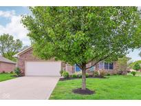 Lovely brick home with a well-maintained lawn, mature trees, and welcoming front porch at 5707 Kensington Blvd, Plainfield, IN 46168