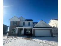 Two-story house with gray brick and white siding, snowy front yard at 18908 Seaforth Way, Westfield, IN 46074