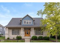 Charming home featuring a brick facade, stylish blue accents, and a well-manicured lawn at 7290 Lockford Walk N, Avon, IN 46123