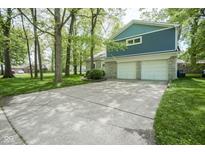 Inviting two-story home featuring a blue-gray exterior, stone accents, an attached two-car garage, and a wide concrete driveway at 1127 Grant Cir, Cicero, IN 46034