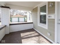Covered front porch with a white mailbox and view of the detached garage at 2814 E 17Th St, Indianapolis, IN 46218