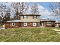 Charming two-story home featuring a brick facade, complemented by green grass and a welcoming entrance at 5230 N County Rd 50 E, Shelbyville, IN 46176