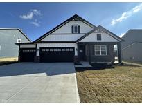Charming home showcasing a black three-car garage, white siding, and brick accents for an inviting curb appeal at 273 Lar Lan Dr, Danville, IN 46122