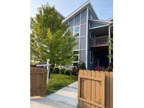Modern, blue two-story townhome with a well-manicured front yard and a charming wood fence at 1213 Cottage Ave, Indianapolis, IN 46203