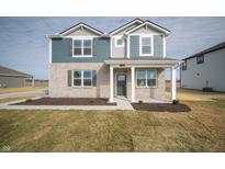 Charming two-story home with brick and siding facade, covered front porch, and well-maintained lawn at 7904 Magnolia St, New Palestine, IN 46163