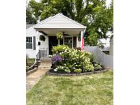 Charming home featuring a quaint front porch, beautiful landscaping and an American flag at 5441 E 17Th St, Indianapolis, IN 46218