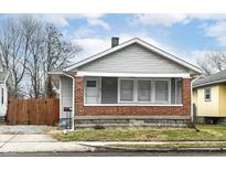 Charming single-story home featuring a brick foundation and neutral siding, under a cloudy sky at 107 S Arlington Ave, Indianapolis, IN 46219