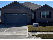 Charming single-story home with a gray brick exterior, well-manicured lawn, and an attached two-car garage at 120 Velvet Hat Rd, Danville, IN 46122