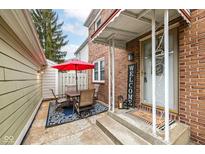 Inviting patio with table, chairs, and umbrella, perfect for outdoor dining at 383 Carmelaire Ct, Carmel, IN 46032