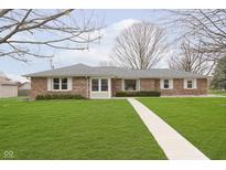 Charming brick home featuring a well-manicured front yard and inviting walkway at 4308 Forest Ter, Anderson, IN 46013
