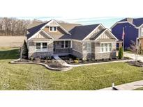 Attractive stone and shingle exterior of a charming ranch home with a manicured lawn at 12535 Tidecrest Dr, Fishers, IN 46037