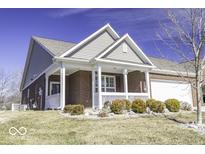 Charming brick home featuring a cozy covered porch with white railings and a well-manicured lawn at 4326 Switchgrass Way, Indianapolis, IN 46237