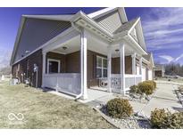 A brick home featuring a covered porch with white railings and a walkway at 4326 Switchgrass Way, Indianapolis, IN 46237