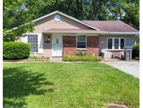 Tan house with brick accents, green lawn, and a partially visible driveway at 3359 Laurel St, Indianapolis, IN 46227