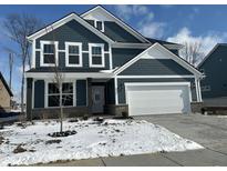 Stunning two-story home featuring gray siding, white trim, and a two-car garage, enhanced by winter snow at 19955 Boulder Brook Ln, Westfield, IN 46074