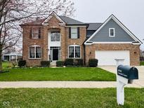 Traditional brick home with a manicured lawn, attached garage, and mature landscaping at 14914 Annabel Ct, Westfield, IN 46074