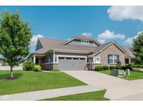 Charming home featuring a well-manicured lawn, gray siding, brick accents, and attached two-car garage at 17345 Northam Dr, Westfield, IN 46074