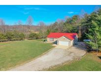 Ranch home with red metal roof, detached garage, and large yard at 7209 Bean Blossom Rd, Morgantown, IN 46160