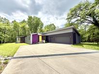 Modern home with a large driveway, two-car garage, and unique color accents at 7650 Clarion Dr, Indianapolis, IN 46236
