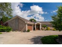 Charming ranch-style home featuring a brick facade, attached garage, and well-maintained landscaping at 9454 Raintree S Dr, Columbus, IN 47201