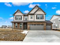Charming two-story home with a brick and vinyl exterior, a three-car garage, and a well-manicured front yard at 20326 N Pacific Ave, Westfield, IN 46074