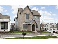 Charming two-story home with gray brick and siding, a covered entryway, and manicured landscaping at 1667 Midland Main St, Westfield, IN 46074