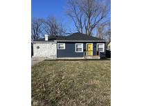 Charming ranch home with a blue exterior, white stone accents, and a yellow front door at 3712 N Bancroft St, Indianapolis, IN 46218