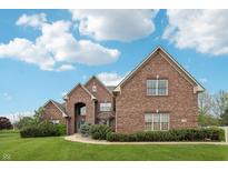 Charming brick two-story home boasts a beautiful lawn and inviting curb appeal at 1038 White Oak Dr, Plainfield, IN 46168